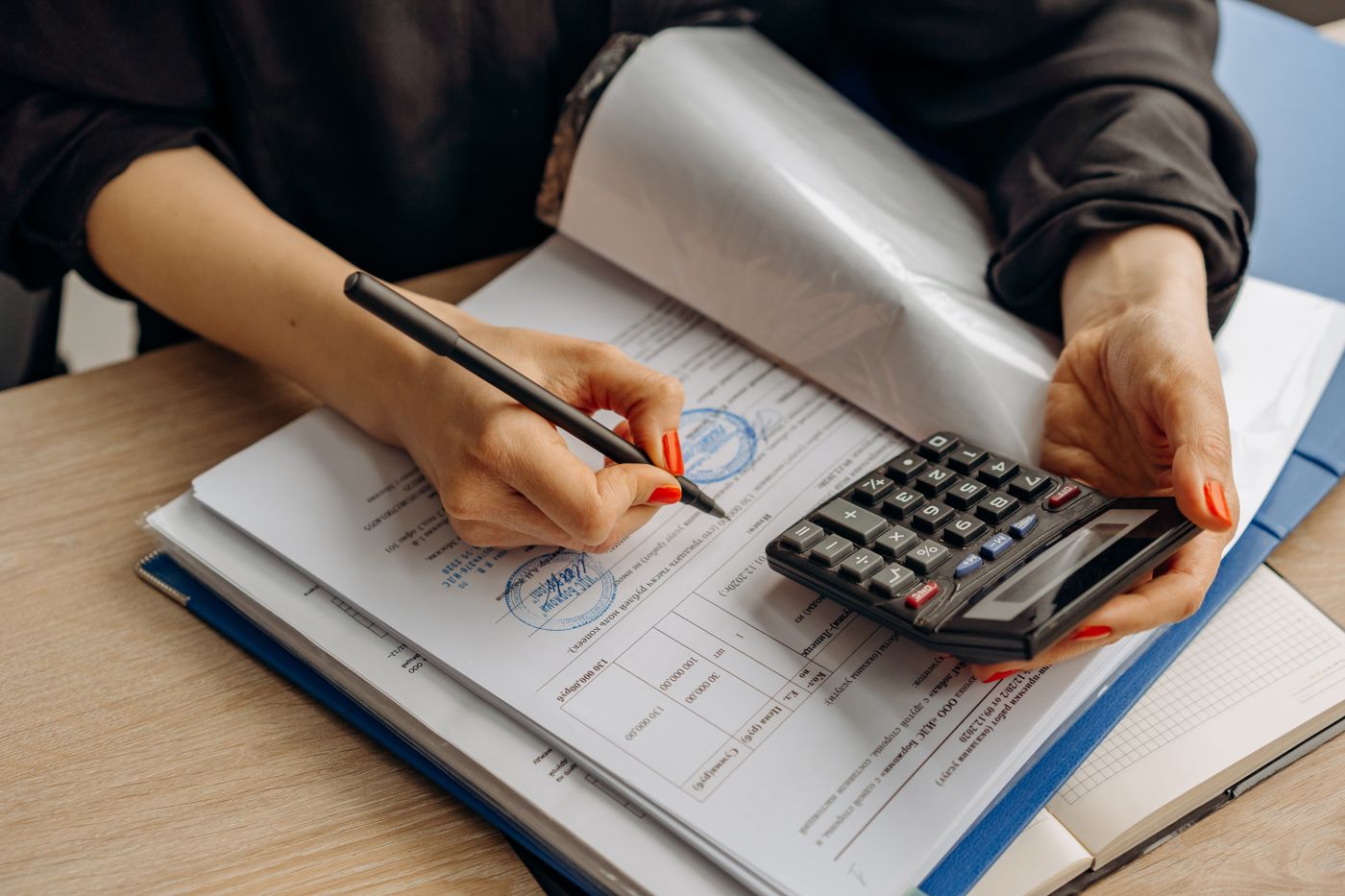 A finance officer checking reports with a calculator