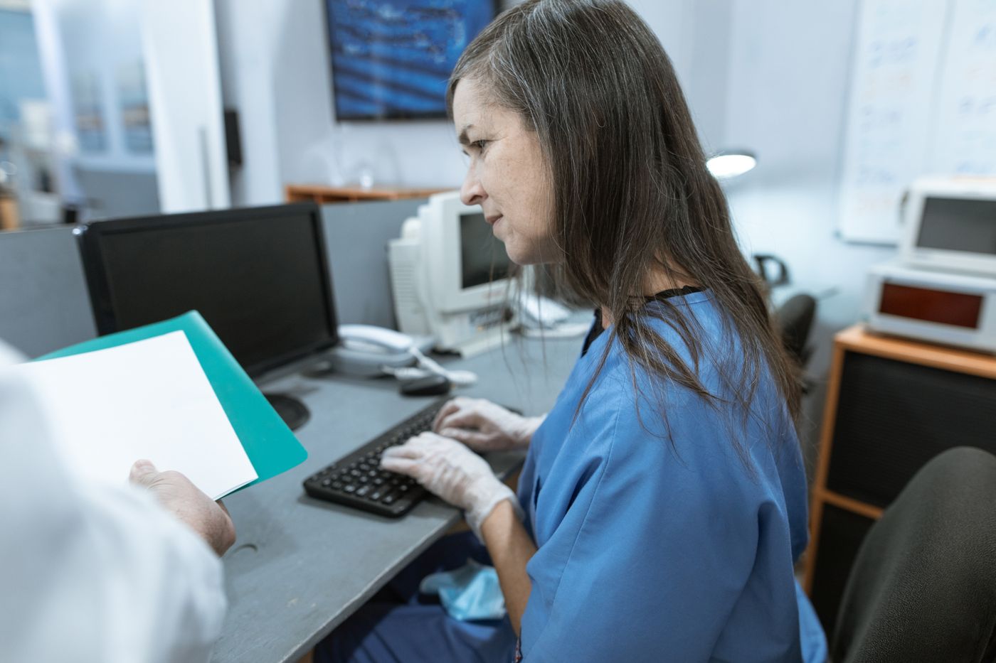 A staff member entering details at a clinic computer