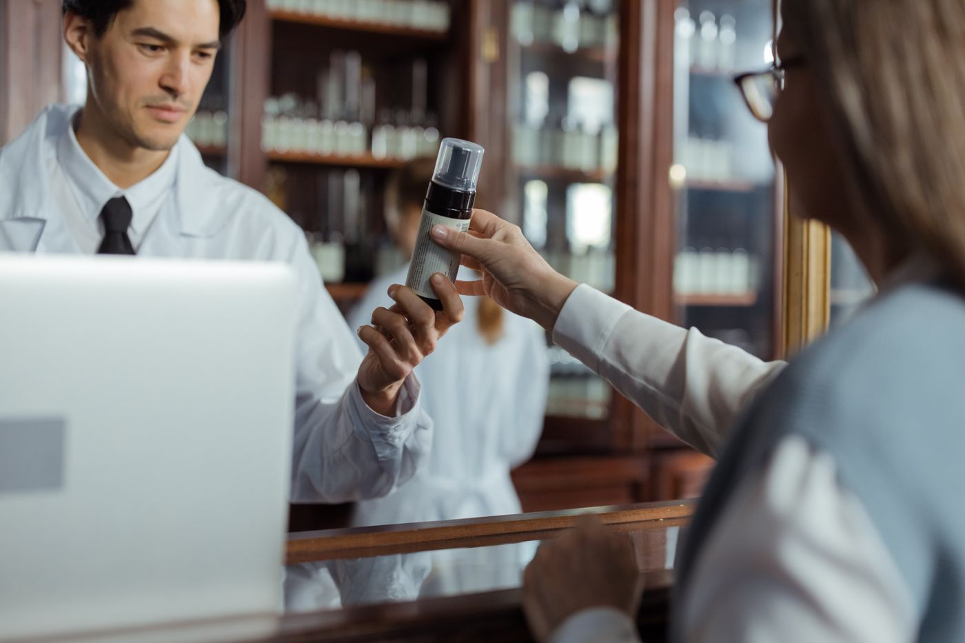A pharmacist handing over medicine at a pharmacy counter