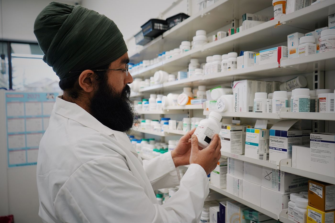 A pharmacist checking stock on the pharmacy shelves
